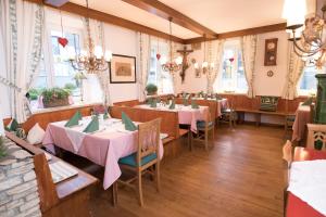 un comedor con mesas, sillas y ventanas en Schlossgasthof, en Artstetten