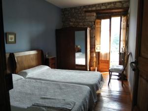 a bedroom with two beds and a mirror at Finca el Palacio in Torín +17 photos