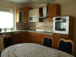 a kitchen with wooden cabinets and a table with a microwave at Apartment Milena in Maribor