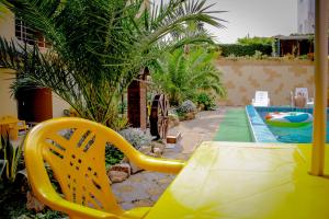 una silla amarilla sentada junto a una piscina en Guest House Planet MOV, en Adler