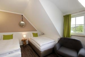 a room with a bed and a chair and a window at Hotel Restaurant Reichsadler in Buchen