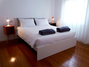 a bedroom with a white bed with two pillows on it at Casa del Corso in Pordenone