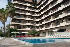 a hotel with a swimming pool in front of a building at Apartaments Cye Salou in Salou