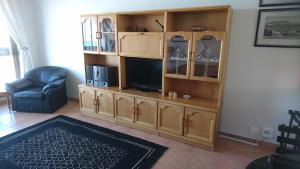 a living room with a entertainment center with a television at Bloubergviews in Bloubergstrand