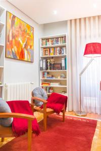 een woonkamer met 2 stoelen en een rood tapijt bij Sunset in São Félix da Marinha