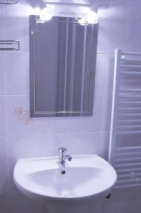 La salle de bains est pourvue d'un lavabo blanc et d'un miroir. dans l'établissement Penzion Eliška, à Petříkov