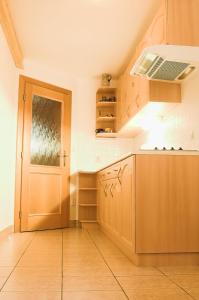 una cocina con armarios de madera y una puerta en Penzion Eliška en Petříkov