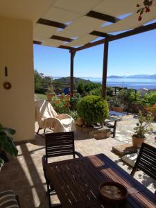 eine Terrasse mit einem Tisch und Stühlen sowie Meerblick in der Unterkunft Fissi Villas agritourism accommodation near the sea in Agios Nikolaos