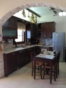 een keuken met een tafel en een koelkast bij Fissi Villas agritourism accommodation near the sea in Agios Nikolaos