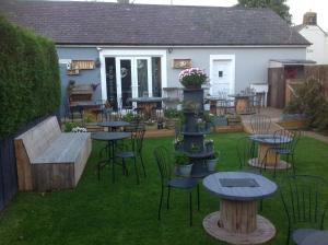 a patio with tables and chairs in a yard at StoneLaw Cottage in Longframlington +20 photos