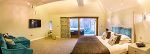 Applegarth Villa Hotel & Restaurant (Adult Only) في ويندرمير: غرفة نوم بسرير كبير وغرفة معيشة