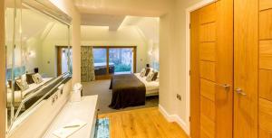 una camera con un letto e un grande specchio di Applegarth Villa Hotel & Restaurant (Adult Only) a Windermere