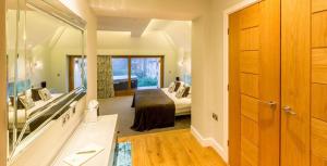 ein Schlafzimmer mit einem Bett und einem großen Spiegel in der Unterkunft Applegarth Villa Hotel & Restaurant (Adult Only) in Windermere