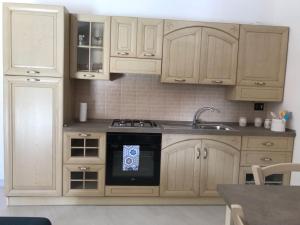 eine Küche mit weißen Schränken und einem Herd mit Backofen in der Unterkunft Lorica Suite in Lorica + 18 Fotos