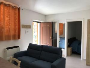 ein Wohnzimmer mit einer blauen Couch und ein Schlafzimmer in der Unterkunft Lorica Suite in Lorica