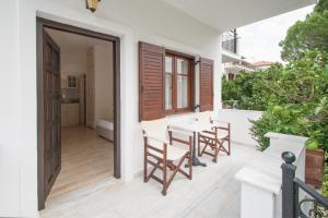 an open door to a patio with a table and chairs at Paris Studios & Apartment in Agia Paraskevi