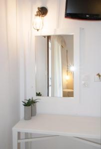 a bathroom with a mirror and a white sink at Paris Studios & Apartment in Agia Paraskevi