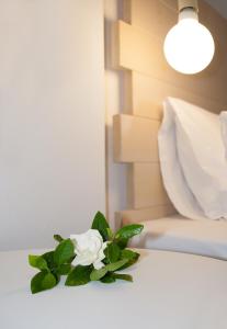 a white flower sitting on top of a bed at Paris Studios & Apartment in Agia Paraskevi