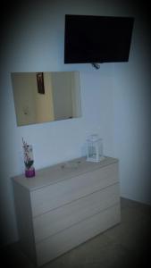 uma cómoda branca com um espelho na parede em Alessi Suites & Studio em Mazzarino