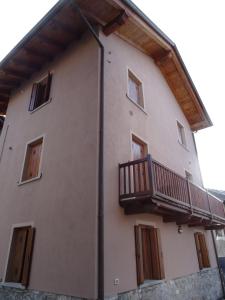 Un edificio con un balcón en el lateral. en Maison D'Antan Alloggio ad uso turistico VDA CHARVENSOD n 0022, en Aosta