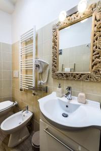 a bathroom with a sink and a mirror and a toilet at Saint Peter Cozy Apartment in Rome +106 photos