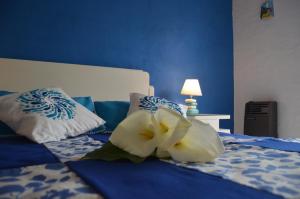 a blue bedroom with a bed with a white flower on it at Aire Marino in Balneario Claromecó
