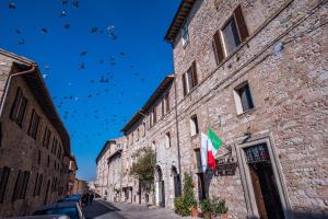 a building with a bunch of flags hanging from it's sides at Hotel Il Palazzo in Assisi