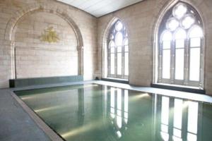 an empty swimming pool in a building with windows at Lovat Loch Ness Apartment with private roof terrace in Fort Augustus
