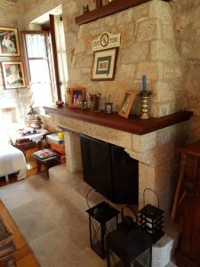 a living room with a stone fireplace with a mantle at Leonidio Stone House in Pragmatevtís