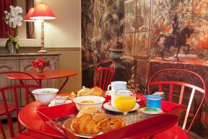Hôtel Perreyve - Jardin du Luxembourg في باريس: طاولة مع طبق من الطعام وعصير البرتقال