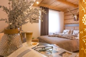 Un dormitorio con una cama y una mesa con un jarrón de flores en Sichlańskie Spanie en Murzasichle