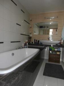 een groot wit bad in een badkamer met een wastafel bij Apartmán Deluxe in Banská Bystrica