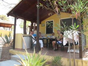 un groupe de personnes assises à une table dans l'établissement Camping Golfo dell'Asinara, à Platamona