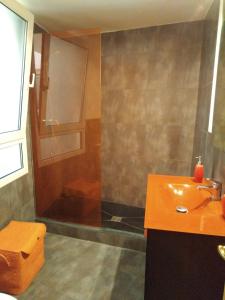 ein Badezimmer mit einem orangenen Waschbecken und einer Dusche in der Unterkunft Ca Tudela Tur in Bocairent