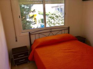 een slaapkamer met een oranje bed en een raam bij Andreas Apartment in Limassol