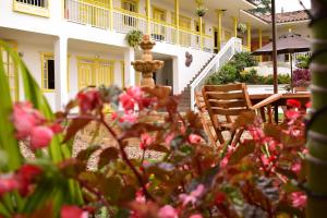 a house with a fountain and flowers in the foreground at Hotel Salento Plaza in Salento