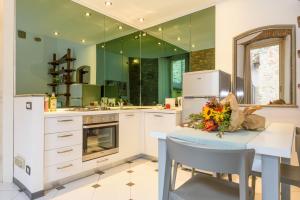 a kitchen with white cabinets and a table with flowers on it at Terrazza Rivola in Bergamo