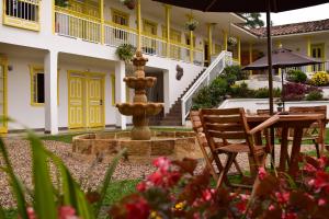 a garden with a fountain in front of a building at Hotel Salento Plaza in Salento
