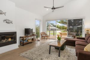 - un salon avec un canapé et une cheminée dans l'établissement Sea View at Silver Sands - C21 SouthCoast Holidays, à Aldinga Beach