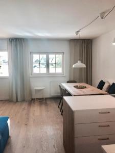 a room with a desk and a table and two windows at See-Apartment Weiden in Weiden am See