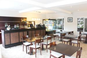 オステンデにあるAyres del Esteのテーブルと椅子とバーのあるレストラン