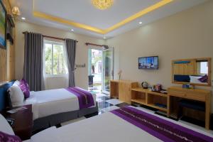 a hotel room with two beds and a television at S79 Stay Sweet Home Phu Quoc in Phu Quoc