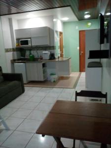 a kitchen and living room with a couch and a table at Ajuricaba Suítes 8 in Manaus