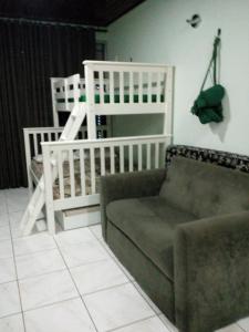 a living room with a couch and a crib at Ajuricaba Suítes 8 in Manaus