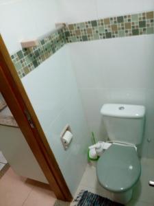 a bathroom with a toilet and a toilet paper dispenser at Ajuricaba Suítes 8 in Manaus