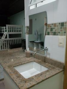 a kitchen counter with a sink and a mirror at Ajuricaba Suítes 8 in Manaus
