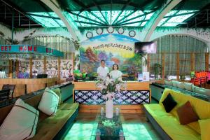 a restaurant with couches and a table with a vase of flowers at S79 Stay Sweet Home Phu Quoc in Phu Quoc +166 photos