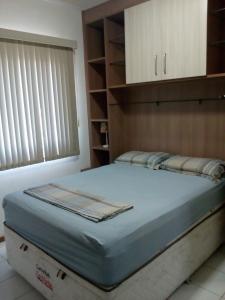 a large bed in a room with a cabinet at Ajuricaba Suites 6 in Manaus