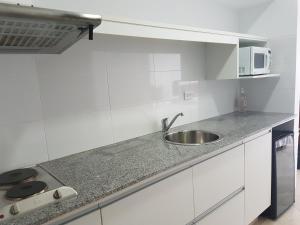 a kitchen with a sink and a microwave at Makana Suite 6-11 in Tonsupa