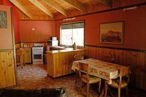 uma cozinha com uma mesa com cadeiras e uma cozinha com um fogão em Wrenwood Chalets em Augusta